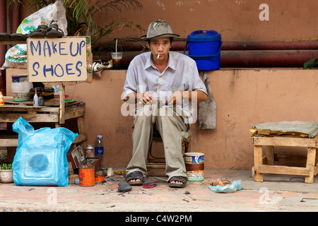Shoe repair street vendor in Cambodia Stock Photo