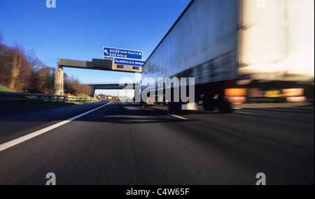 articulated lorry passing under direction gantry on the a1/m motorway near Leeds Yorkshire UK Stock Photo
