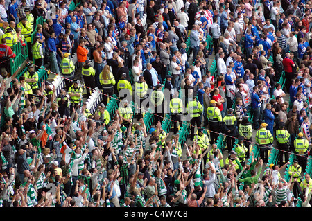 Celtic v Rangers: Celtic fans celebrate victory over Rangers fans, while police segregate the two sets of supporters Stock Photo