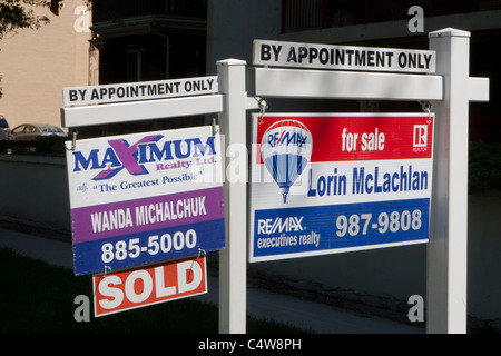 'For sale' signs for Maximum realty and Re/Max are seen next to each other in Winnipeg Thursday May 26, 2011. Stock Photo