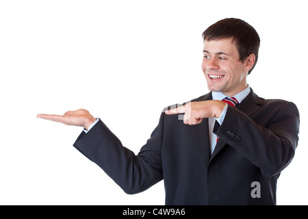 Young businessman points to ad text in his palm and smiles. Isolated on white background. Stock Photo