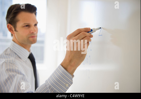 USA, New Jersey, Jersey City, Businessman writing on whiteboard Stock Photo
