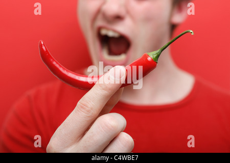 A man eating chili pepper Stock Photo