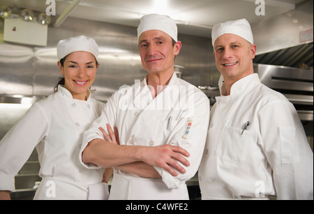 USA, New York State, New York City, Three chefs posing in kitchen Stock Photo