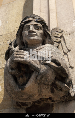 A winged gargoyle looks out over Oxford from the walls of Magdalen College. Stock Photo