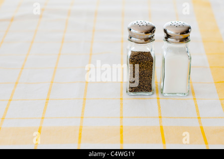 Salt and pepper shakers on checked tablecloth Stock Photo