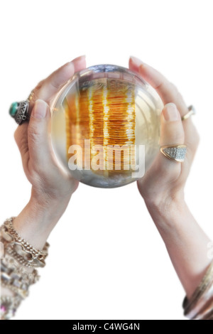 woman's hands holding crystal ball and divining a prosperous future. High key. Stock Photo