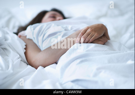 USA, New Jersey, Jersey City, Young woman daydreaming in bed Stock Photo