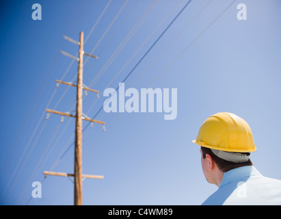 USA, California, Palm Springs, Coachella Valley, San Gorgonio Pass, Man in hard hat looking at telephone pole Stock Photo