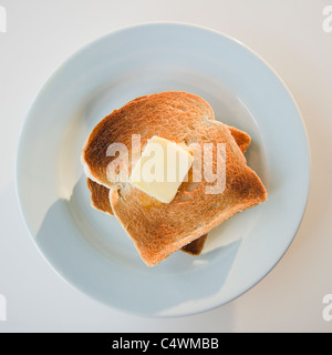 Close up of toasts with butter on plate Stock Photo