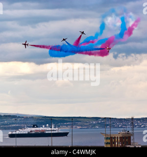 Red Arrows in formation over Leith Harbour and visiting cruise ship Minerva, Armed Forces Day, June 24 2011, Edinburgh, Stock Photo