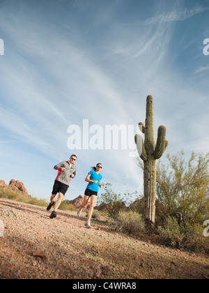 USA, Arizona, Phoenix, Mid adult man and young woman jogging on desert Stock Photo
