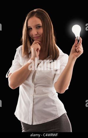 Young attractive businesswoman holding illuminated bulb Stock Photo
