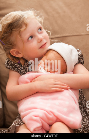 USA, Utah, Lehi, Girl (2-3) embracing baby sister on sofa Stock Photo