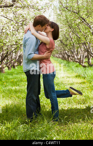 USA,Utah,Provo,Young couple kissing in orchard Stock Photo