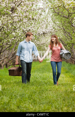 USA,Utah,Provo,Young couple with picnic basket in orchard Stock Photo