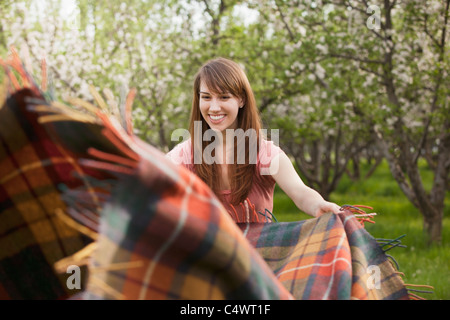 USA,Utah,Provo,Young woman holding blanket in orchard