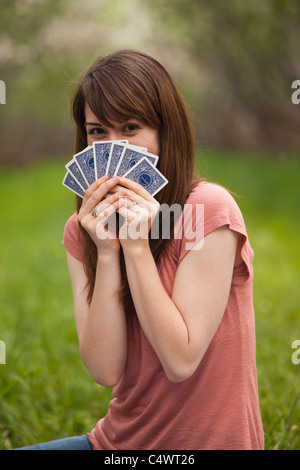 USA,Utah,Provo,Young woman playing cards in orchard