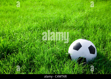 football or soccer ball on the green grass field Stock Photo