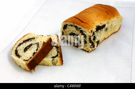 cut baked roll with poppy seeds on white napkin Stock Photo