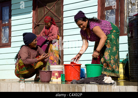 Three Nepalese women washing in buckets, Bandipur, Western Region, Nepal Stock Photo