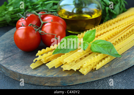cherry tomatoes on a branch, basil, pasta and olive oil Stock Photo