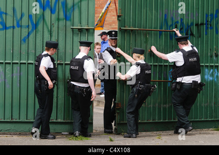Police officers open the gates at the Peace Wall separating Protestant Workman Avenue from the Catholic Springfield Road. Belfast 25/06/2011 Stock Photo