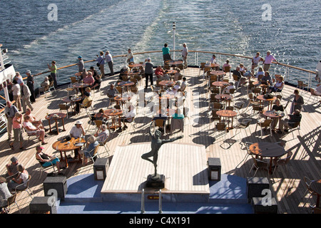 Passengers sitting on the lido deck of a cruise ship in the sunshine Stock Photo