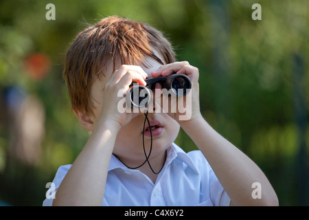 portrait of a young boy looking through binoculars Stock Photo