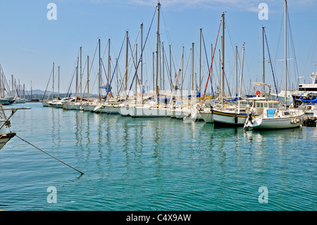 Yachts with their sails furled moored in the blue sea of the pretty little inner harbour of Toulon Stock Photo