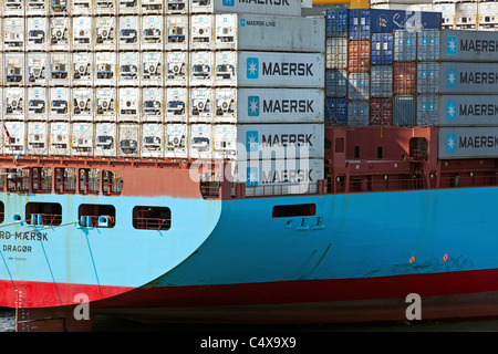 Cargo container ship in port harbor at Barcelona, Spain. Maersk containers sitting on board cargo ship in the Mediterranean Sea. Stock Photo