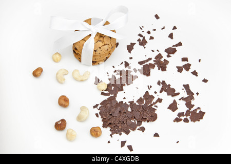 three chocolate biscuits as a gift wrapped with ribbon and chocolate chips and nuts Stock Photo