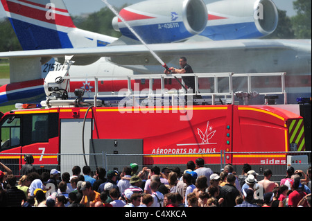 French Firefighters cooling crowd during  extremely hot weather, at Le Bourget airshow 2011 Stock Photo