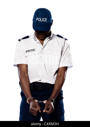 Hand cuffed police officer with head down standing on white isolated background Stock Photo