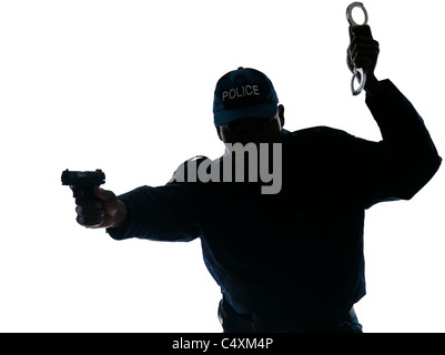 Silhouetted Afro American policeman aiming handgun while holding handcuffs isolated on white background Stock Photo
