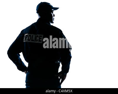 Rear view of a serious afro American policeman with hands on hip looking to his side on white isolated background Stock Photo