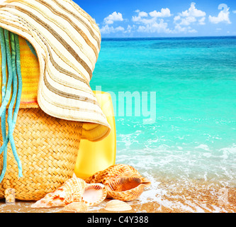 Beach items over blue sea conceptual image of summertime vacation & holidays Stock Photo