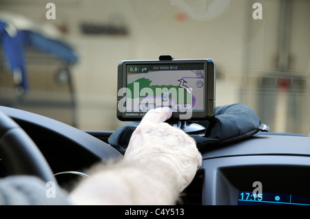 Garmin satnav in holder on dashboard of an lefthand drive car Man planning route Stock Photo