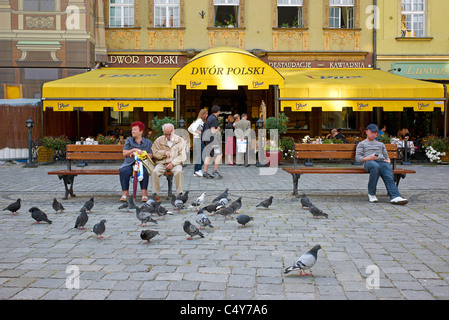 Pigeons and people in front of the restaurant Dwor Polski on the market square, Wroclaw, Poland Stock Photo