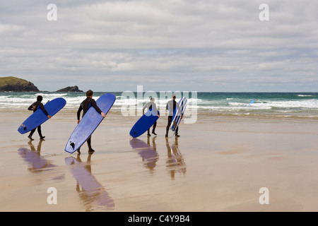 A Group Of Surfers Carrying Their Surfboards Walking Down To The Sea At a-group-of-surfers-carrying-their-surfboards-walking-down-to-the-sea-at
