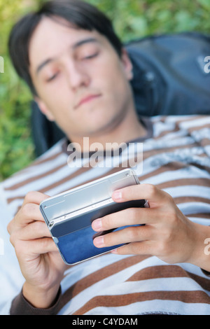 Young man with his PDA on a green grass Stock Photo