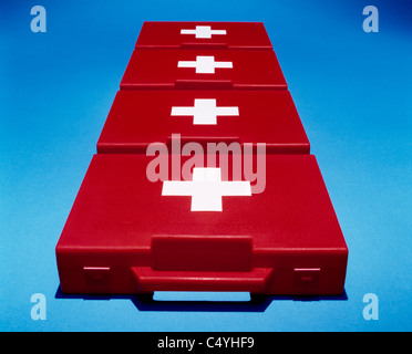 Four bright red first aid medical boxes on a blue background Stock Photo
