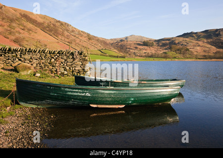 Watendlath, Cumbria, England, UK. Wooden fishing boats on shore of Watendlath Tarn in the fells of Lake District National Park Stock Photo