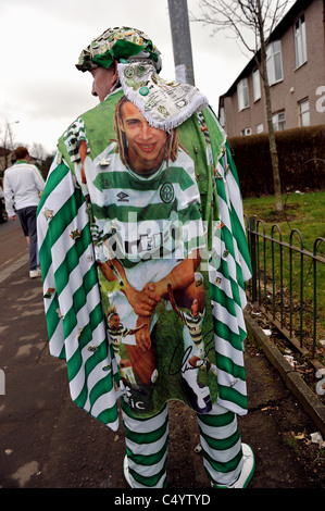 A Celtic fan arrives at Hampden Park for the Scottish League Cup final against Rangers in 2011 bedecked in the club's colours. Stock Photo