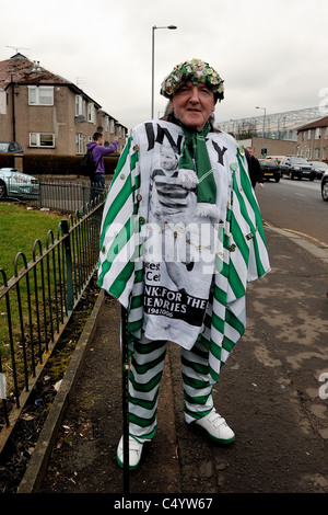 A Celtic fan arrives at Hampden Park for the Scottish League Cup final against Rangers in 2011 bedecked in the club's colours. Stock Photo