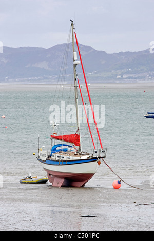 A yacht beached at Beaumaris on the Isle of Anglesey in North Wales, at low tide Stock Photo