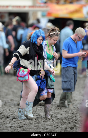 Two girls in the mud at the Glastonbury Festival 2011 Stock Photo