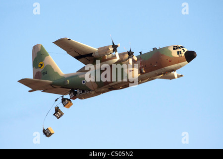 Israeli Air force C-130 Hercules 100 transport plane in flight drops cargo to the troups on the ground Stock Photo
