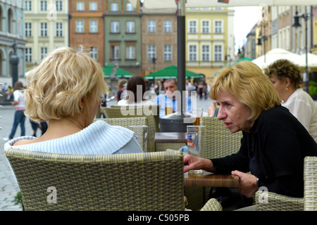 Two women in a street cafe in the Old Market Square, Poznan, Poland Stock Photo