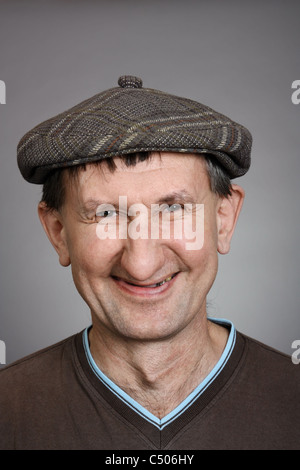 Real laughing man in a cap with a gray background Stock Photo